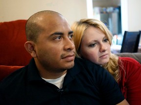 Dallas Police Department Officer Jorge Barrientos, left, is pictured recovering at his home with his girlfriend, Bethany Knutson, Sunday, July 10, 2016, in Dallas. Barrientos was shot in the hand and struck by shrapnel when a gunman attacked officers at a protest against police brutality July 7, 2016. He recounted desperately trying to help fellow officers who were shot, including three from his unit who died. (AP Photo/Christine Armario)