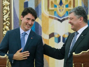 Ukrainian President Petro Poroshenko, right, and Canadian Prime Minister Justin Trudeau smile as they talk to each other during a signing ceremony in Kiev, Ukraine, Monday, July 11, 2016. Trudeau oversaw the signing of a free trade agreement with Ukraine on Monday after he and his son spent the morning commemorating the victims of mass atrocities perpetrated by the Nazis and Soviets. (AP Photo/Efrem Lukatsky)