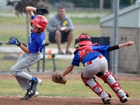 Mitchell Pee Wee catcher Wyatt Huitema (right) reaches to tag out this Simcoe runner during action from the Mitchell minor baseball tournament last Saturday morning, a 31-5 win. ANDY BADER MITCHELL ADVOCATE