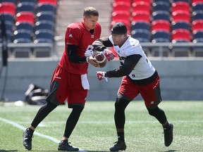 Ottawa Redblacks Trevor Harris passes the ball to Nic Grimsby during practice at TD Place in Ottawa on July 11, 2016. (Tony Caldwell/Postmedia)