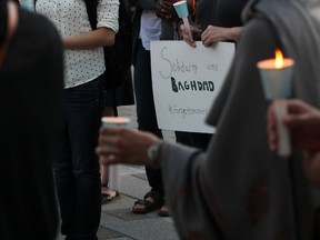 People gathered in Springer Market Square in Kingston to light candles in solidarity with the victims of the terror attack in Baghdad last week. Jane Willsie for The Kingston Whig Standard.