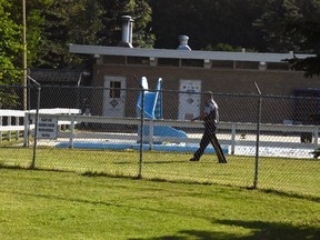 A Grande Prairie RCMP officer patrols Bear Creek Pool on Tuesday July 12, 2016 after a four-year-old boy was reported missing the evening before and later found dead at the bottom of the pool.