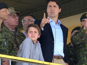 Prime Minister Justin Trudeau (C) and his son Xavier watch Ukrainian military exercises with Canadian military instructors at the International Peacekeeping and Security Center in Yavoriv, near Lviv, on July 12, 2016. (YURIY DYACHYSHYN/AFP/Getty Images)