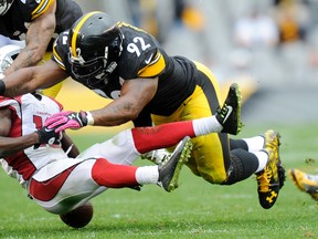Arizona Cardinals wide receiver John Brown (12) fumbles after being hit by Pittsburgh Steelers linebacker James Harrison (92) Sunday, Oct. 18, 2015, in Pittsburgh. (AP Photo/Don Wright)