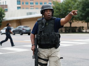 A Dallas police officer helps tighten security at their headquarters after receiving an anonymous threat against law enforcement across the city on  July 9. (AP Photo)