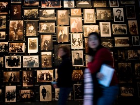People walk past a wall of photos at the U.S. Holocaust Memorial Museum Jan. 26, 2007 in Washington, DC.   (Photo by Brendan Smialowski/Getty Images)