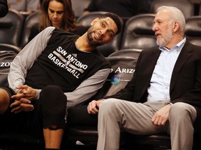 In this Feb. 28, 2015, file photo, San Antonio Spurs forward Tim Duncan, left, and head coach Gregg Popovich chat on the bench during the first quarter of an NBA basketball game against the Phoenix Suns in Phoenix. (AP Photo/Rick Scuteri, File)