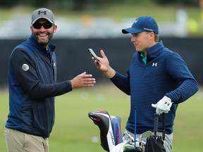 Jordan Spieth, right, laughs with his caddie Michael Greller as he holds a smart phone on the practice ground ahead of the British Open at the Royal Troon Golf Club in Troon, Scotland, Tuesday, July 12, 2016. (AP Photo/Ben Curtis)