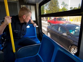 Constable John Porter of the London Police looks through the window at a motorist using a cell phone on Oxford Street in London. Porter called a fellow officer following the bus with a description, license plate and the ticket for distracted driving soon followed. (MIKE HENSEN, The London Free Press)