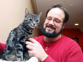 Richard Paquette Jr., of  Rainbow District Animal Control, pets Tasha at the Small Things Cats store in February. Council decided Tuesday that the municipality will own and operate animal pound and shelter services on a one-year trial basis. (Gino Donato/Sudbury Star file photo)
