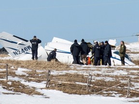 National Transportation Safety Board inspectors go over the wrecked airplane in a field Wednesday, March 30, 2016 in Havre-aux-Maison, Quebec where ex-cabinet minister Jean Lapierre, his wife Nicole Beaulieu, two of his brothers and one sister died in a failed landing Tuesday. THE CANADIAN PRESS/David Noel