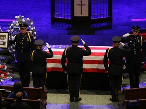 Law enforcement officers salute the casket of Dallas Police Sr. Cpl. Lorne Ahrens during his funeral service at Prestonwood Baptist Church in Plano, Texas, Wednesday, July 13, 2016.  Ahrens and four other officers were slain by a sniper during a protest last week in downtown Dallas. (AP Photo/LM Otero)