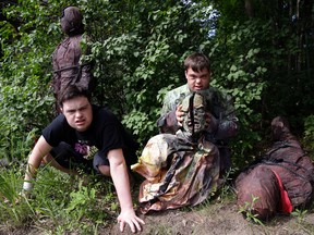 In this July 12, 2016 photo, Sam Suchmann, left, and Mattie Zufelt pose with ghoulish figures at Sam's home in Providence, R.I. Suchmann and Zufelt, best friends with Down syndrome, are living their dreams of making a full-length, epic zombie movie and becoming celebrities. The duo premiered their movie, “Spring Break Zombie Massacre,” in Providence last week, have been invited to several film festivals in North America, and are scheduled to appear on “Conan” Thursday. (AP Photo/Elise Amendola)