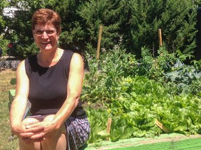 Mara Shaw, executive director of the Loving Spoonful, sits by the office's backyard garden in Kingston on July 4, 2016.  Jane Willsie for The Whig-Standard/Postmedia Network