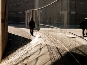 A man walks past the vitreous facade of the Neues Museum (New Museum) reflecting the morning sun in Nuremberg, southern Germany, on February 7, 2015. AFP PHOTO/ANIEL KARMANN
