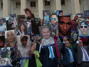 Members and supporters of the US Congressional LGBT Equality Caucus hold pictures of victims of the Pulse nightclub attack, one month after a gunman killed 49 people at the club in Orlando, Florida, during a vigil on the East House steps of the US Capitol in Washington, DC, on July 12, 2016. / AFP PHOTO / NICHOLAS KAMMNICHOLAS KAMM/AFP/Getty Images