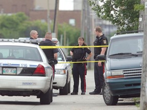 Police work at the scene east of Arlington Street in a lane north of William Avenue where a man died as a result of being tasered by Winnipeg police on Tues., July 22, 2008.