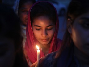 A Pakistani Christian girl holds a candle during a vigil for victims of a deadly suicide bombing on Easter, in Lahore, Pakistan, Monday, April 4, 2016. The massive suicide bombing claimed by a breakaway Taliban faction targeted Christians gathered for Easter Sunday in a park in Lahore. (AP Photo/K.M. Chaudary)