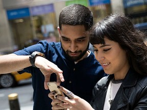 Sameer Uddin and Michelle Macias play Pokemon Go on their smartphones outside of Nintendo's flagship store, July 11, 2016 in New York City. The success of Nintendo's new smartphone game, Pokemon Go, has sent shares of Nintendo soaring. (Photo by Drew Angerer/Getty Images)