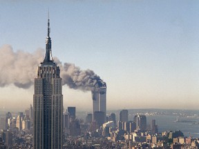 In this Sept. 11, 2001 file photo the twin towers of the World Trade Center burn behind the Empire State Building in New York after terrorists crashed two planes into the towers causing both to collapse. (AP Photo/Marty Lederhandler)