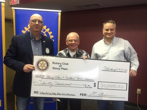 Stony Plain Rotary Club president Graham Anderson, left, presents Pioneer Museum president Duncan Schoepp and executive director David Fielhaber with a $30,000 cheque, which will be used to build cabinets for their antique oil lamp collection. - Photo submitted