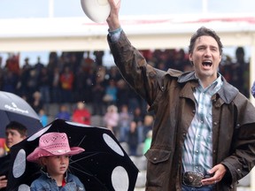 Prime Minister Justin Trudeau with daughter Ella-Grace waves to the crowds during the start of the rodeo at the Calgary Stampede in Calgary, Alta., on Friday July 15, 2016. Leah Hennel/Postmedia