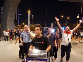 Passengers leave Ataturk Airport as Turkish army tanks enter Istanbul on July 16, 2016. Bridges across the Bosphorus, the strait separating the European and Asian sides of the city, have been closed to traffic.