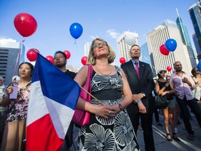 Wendy Feldman holds a French flag during a vigil for the victims of attack in Nice at Nathan Phillips Square in Toronto. (ERNEST DOROSZUK, Toronto Sun)