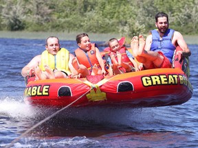 Companion Jordan Faggioni, with campers Miguel and Michael and fellow companion Brent Lamborn, have some fun tubing on the West Arm of Lake Nipissing at Camp Quality in Monetville. (Gino Donato/Sudbury Star)
