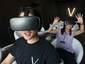 Gary Tam, Co-founder of Vivid VR gives Sun reporter Jenny Yuen  a tour of the virtual reality experience at the Dundas Street West theatre pop-up just opened, on Saturday July 16, 2016. Stan Behal/Toronto Sun/Postmedia Network