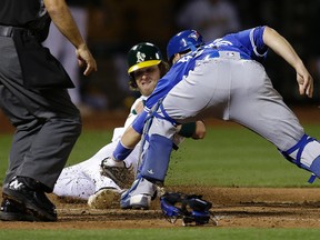 Josh Reddick of the A's just beats the throw home for the eventual winning run in Friday's 8-7 victory over the Jays. (AP)