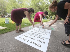 Stencils, and transported water,  were used by a group of people to bring attention to Shoal Lake 40, in Steven Juba Park, in Winnipeg.  Saturday, July 16, 2016.  Sun/Postmedia Network