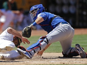 Toronto Blue Jays catcher Josh Thole, right, tags out Oakland Athletics’ Marcus Semien Saturday, July 16, 2016, in Oakland, Calif. (AP Photo/Ben Margot)