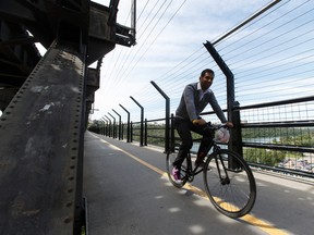 A cyclist crosses the west sidewalk of the High Level Bridge in Edmonton. Mayor Don Iveson has apologized for some terse comments related to the ongoing controversy over bike lanes and suicide barriers on the bridge.