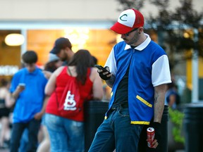 Michael Young, dressed as Pokemon character Ash Ketchum, plays "Pokemon Go, " in Springfield, Mo. on Friday, July 15, 2016. "Pokemon Go," a free mobile app partly owned by Nintendo, allows people to collect and battle Pokemon in the real world. (Guillermo Hernandez Martinez/The Springfield News-Leader via AP)