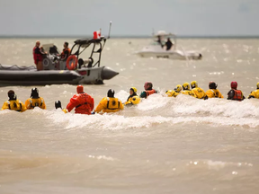 Central Elgin volunteer firefighters from Union and Port Stanley departments form a line to search for the body of William Johnston who is presumed drowned after disappearing into heavy waves Thursday afternoon. They were searching near where Johnston was last seen off the main beach in Port Stanley south of London, Ont. on Friday July 15, 2016. Mike Hensen/The London Free Press/Postmedia Network