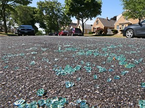 Broken auto glass is scattered in the street in the 3500 Blk. of S. 17th St. in Milwaukee, where a Milwaukee Police officer was shot while seated in the front seat of his squad car early Sunday, July 17, 2016.    (Michael Sears/Milwaukee Journal Sentinel via AP)