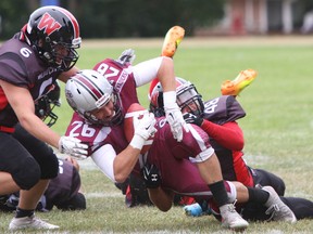 Kingston Grenadiers’ Herry Robinson is taken down by the Cornwall Wildcats’ Tyler Fyckes during Ontario Varsity Football League varsity division action at Loyalist Collegiate on Saturday. The Grenadiers defeated the Wildcats 35-7. (Steph Crosier/The Whig-Standard)