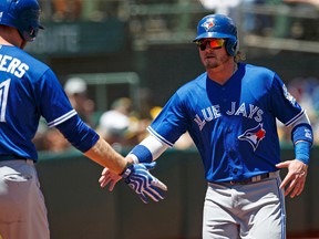 Josh Donaldson #20 of the Toronto Blue Jays is congratulated by Michael Saunders #21 after scoring a run against the Oakland Athletics during the first inning at the Oakland Coliseum on July 17, 2016 in Oakland, California. (Photo by Jason O. Watson/Getty Images)