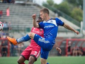 Jake Keegan of FC Edmonton gets a shot off as Eddie Edwards of the Ottawa Fury tries to defend on Sunday at Clark Park. (Shaughn Butts)