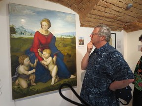 A visitor studies a forgery of Raphael's Madonna of the Meadow at Vienna's Museum of Art Fakes. The original hangs in the city's Kunsthistorisches Museum. LANCE HORNBY/Postmedia Network