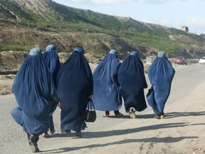 Afghan women walk along the street on the outskirts of Kabul, Afghanistan, Monday, April 4, 2016. (AP Photo/Rahmat Gul)