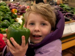 A child holds up a green pepper in this undated photo.