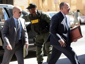 Lt. Brian Rice, left, one of the six members of the Baltimore Police Department charged in connection to the death of Freddie Gray, arrives with attorney Mike Davey, right, at a courthouse to hear a judge's ruling in his trial in Baltimore, Monday, July 18, 2016. Rice is the fourth of the six officers charged to go on trial in the 2015 death of Freddie Gray. (AP Photo/Steve Ruark)