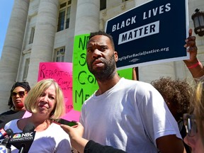 Lawyer Patricia Kane of New Haven, second from left, with her client Corey Menafee, a former employee at Yale's Calhoun College who was arraigned for breaking a window pane depicting black slaves picking cotton at Calhoun College, right, talk with the press as they leave New Haven Superior Court on Chapel Street in New Haven Tuesday, July 12, 2016. (Peter Hvizdak /New Haven Register via AP)