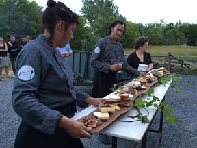 Chef Jamie Kennedy, centre, oversees the cheese plate for guests at his farm dinner in Prince Edward County on July 9, 2016. (Postmedia Network)