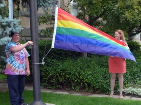 Skyler Moyes, left, raises the rainbow flag at city hall with the help of St. Thomas Mayor Heather Jackson Monday morning. The flag raising ceremony marks the beginning of St. Thomas' first ever Pride Week celebration.