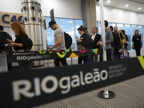 Passengers wait to board in a rail line at the Tom Jobim International airport in Rio de Janeiro, Brazil, Thursday, July 7, 2016. (AP Photo/Silvia Izquierdo)