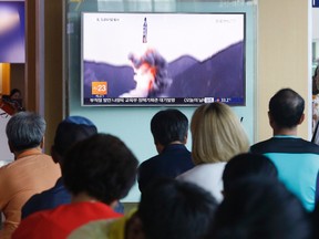 People watch a TV news program showing file footage of North Korea's ballistic missile that the North claimed to have launched from underwater, at Seoul Railway station in Seoul, South Korea, Saturday, July 9, 2016. North Korea on Tuesday fired three ballistic missiles into its eastern sea in an apparent protest of South Korea's decision to allow the deployment of an advanced U.S. missile defence system in the country, Seoul officials said. (AP Photo/Ahn Young-joon)