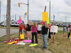 Rob Gee and about a dozen others protest on the corner of Underwood Road and Ingersoll Street on Tuesday, July 19, 2016. Unifor Local 2163 is hoping to draw attention to an employee whose parental leave was allegedly denied by Autrans Corporation. (MEGAN STACEY/Sentinel-Review)